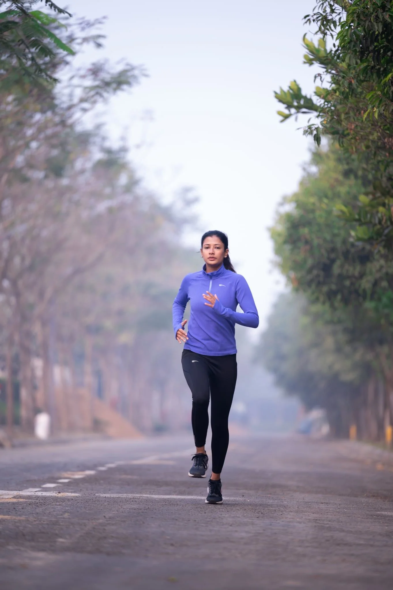 Runner wearing a Roc Street training top on a city path