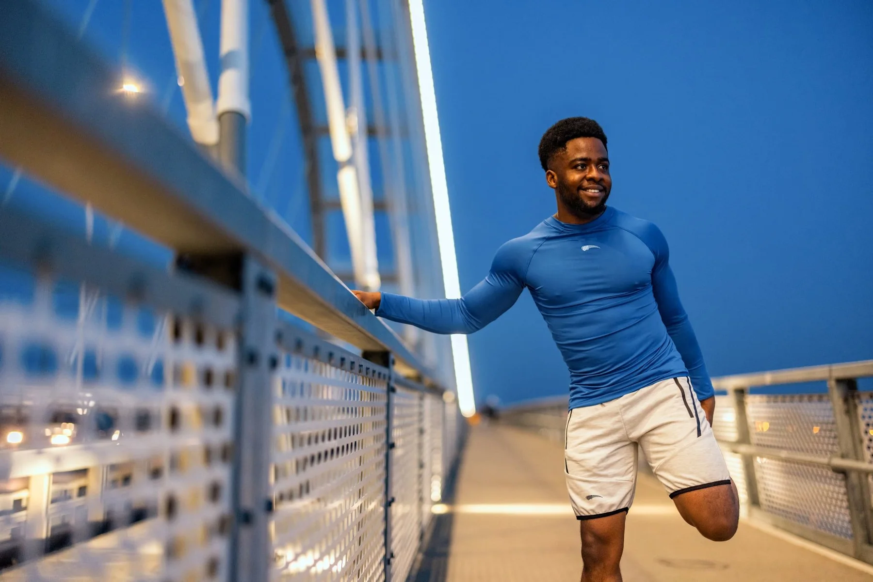 Athlete in a blue Roc Street tennis outfit beside a court net